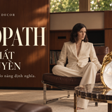 Banner Leopath – Khí chất nữ quyền: tượng báo sắc vàng trên quả cầu pha lê, bên người phụ nữ mặc suit kem trong không gian gỗ ấm.